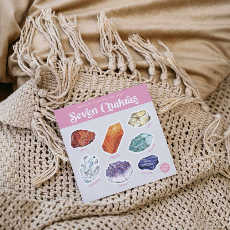 a picture of the seven chakras watercolor crystal sticker sheet on a blanket