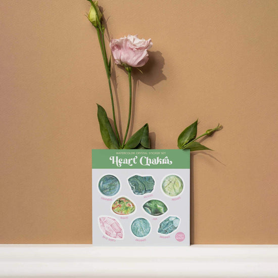 a heart chakra watercolor crystal sticker set with a flower in a vase on a shelf