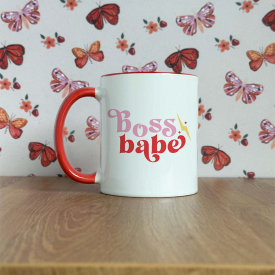 a red and white coffee mug sitting on top of a wooden table