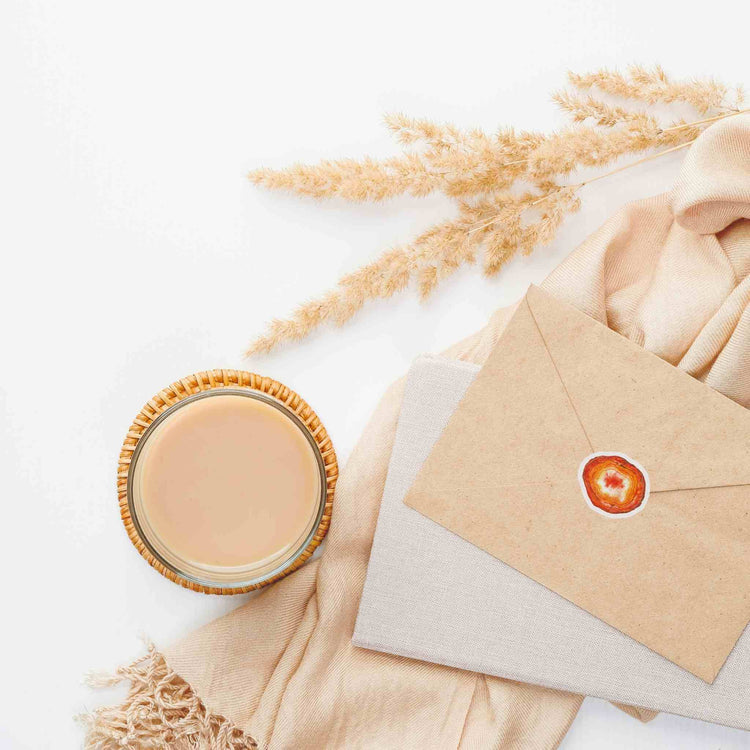 a cup of coffee next to an envelope with carnelian stickers from sacral chakra watercolor crystal sticker set