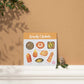 a sacral chakra watercolor crystal sticker set sitting on top of a shelf next to a plant
