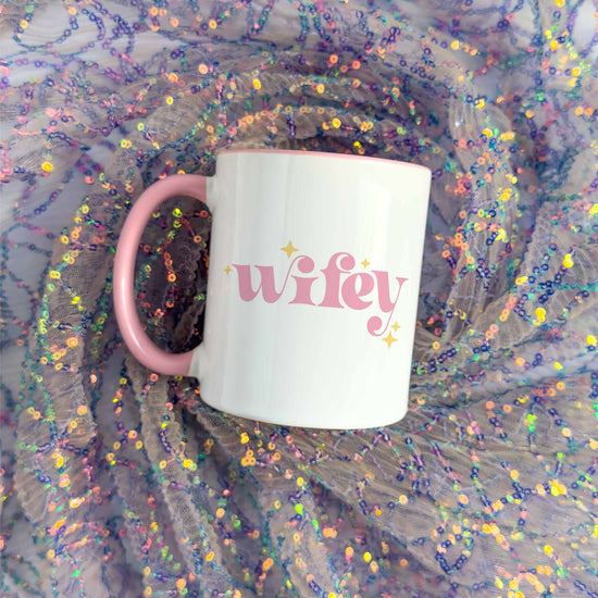 a pink and white coffee mug with the word wife on it