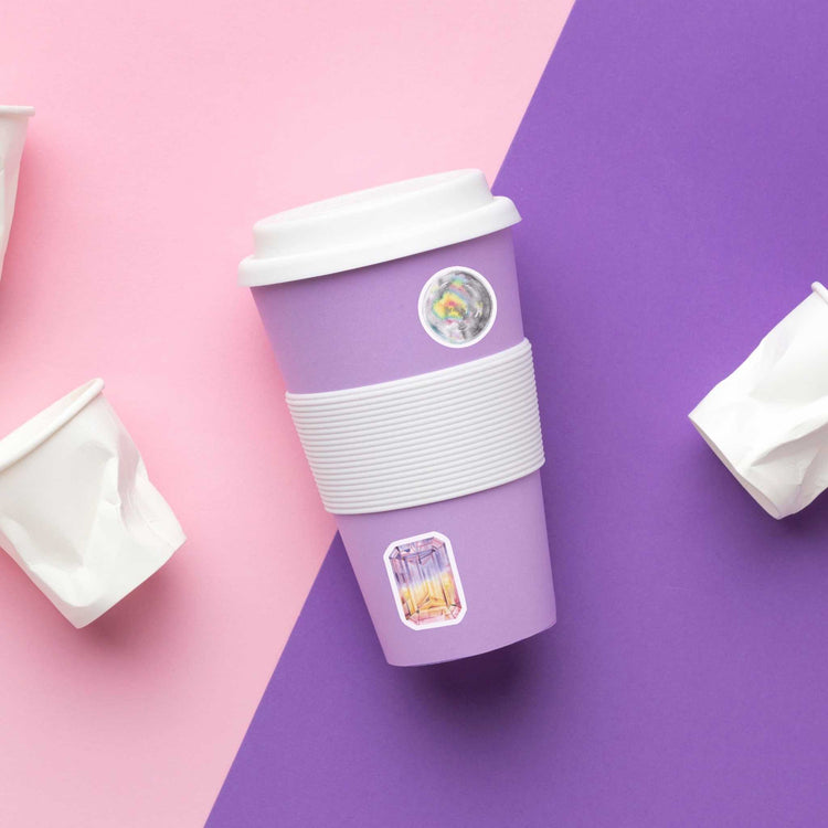 a cup of coffee on a purple and pink background with watercolor crystal stickers for the crown chakra
