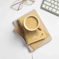 a cup of coffee sitting on top of a notebook with solar plexus crystal stickers on it next to a keyboard