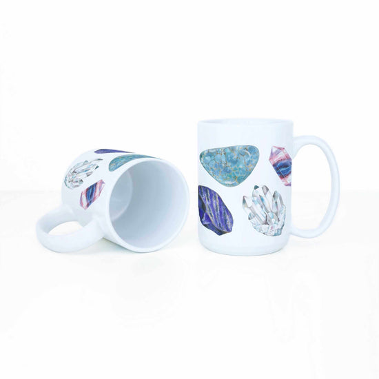 a white coffee mug with a picture watercolor crystals representing the 7 chakras