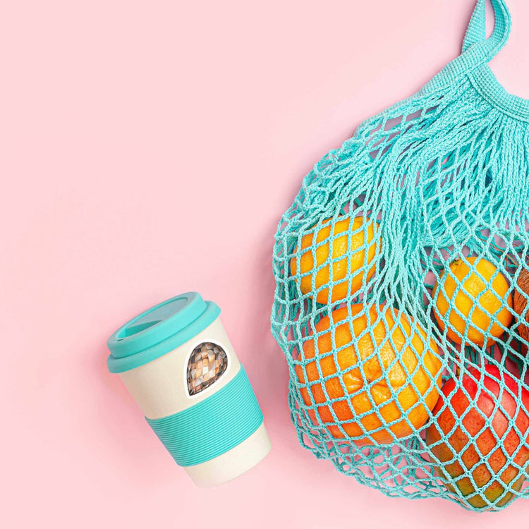 a mesh bag of fruit next to a cup of coffee with a smoky quartz sticker from root chakra crystal sticker set