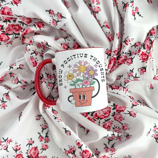 a red coffee mug sitting on top of a white blanket