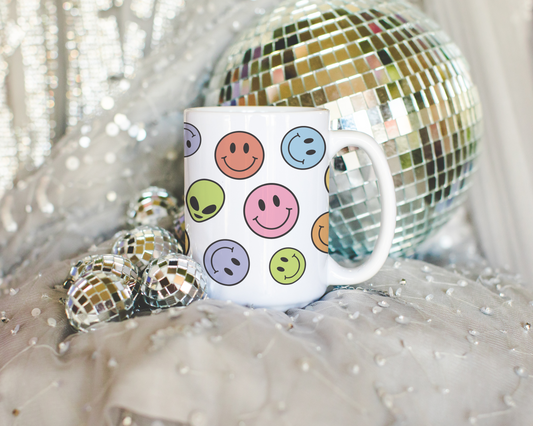 a white coffee mug with smiley faces on it