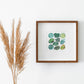 a picture of the Heart Chakra Watercolor Crystal Art Print hanging on a wall next to a plant
