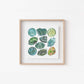 a white wall with a wooden frame holding a picture of heart chakra Watercolor Crystal Art Print