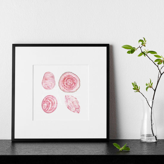 a picture of the love stoned Watercolor Crystal Art Print leaning on a wall next to a plant