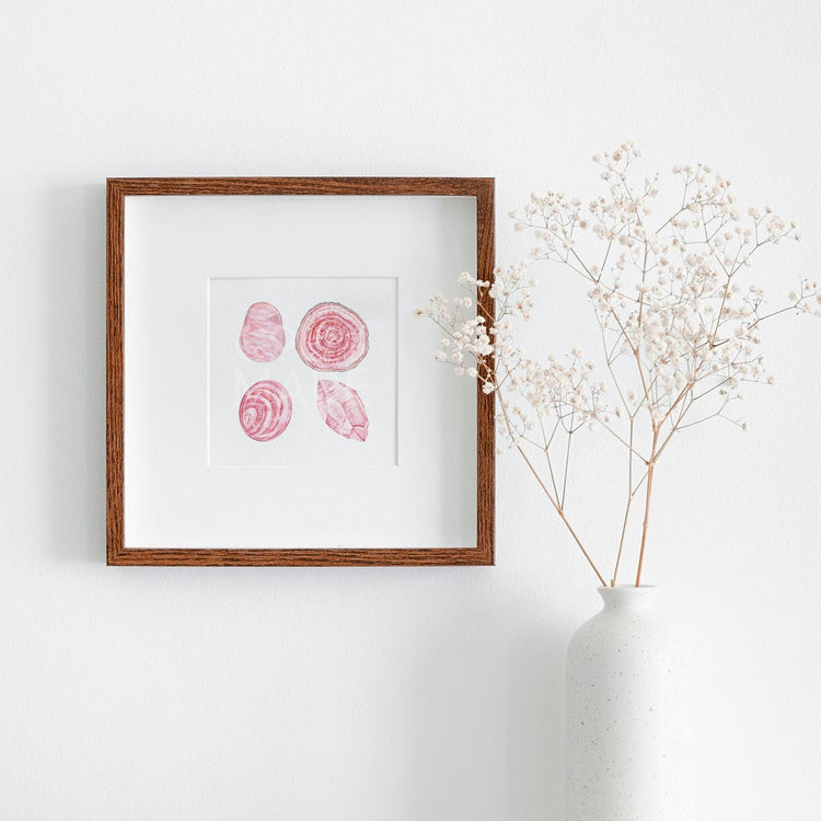 a picture of the love stoned Watercolor Crystal Art Print hanging on a wall next to a plant