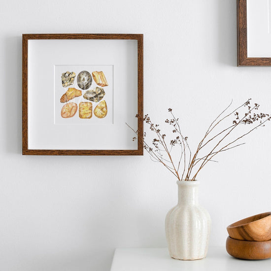 Solar Plexus Chakra Watercolor Crystal Art Print hanging on the wall next to a white vase on a table