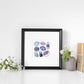 Framed Third Eye Chakra Watercolor Crystal Art Print on a shelf with plants