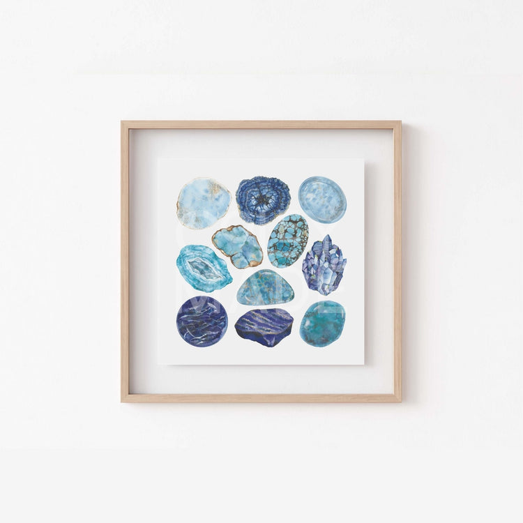 a white wall with a wooden frame holding a picture of the throat Chakra Watercolor Crystal Art Print