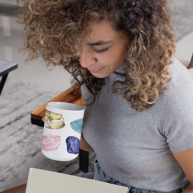 a white coffee mug with a picture watercolor crystals representing the 7 chakras